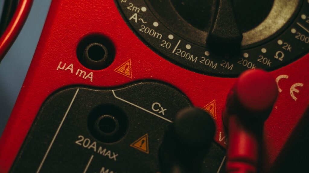 Digital wire gauge tester and multimeter measuring electical cable thickness.